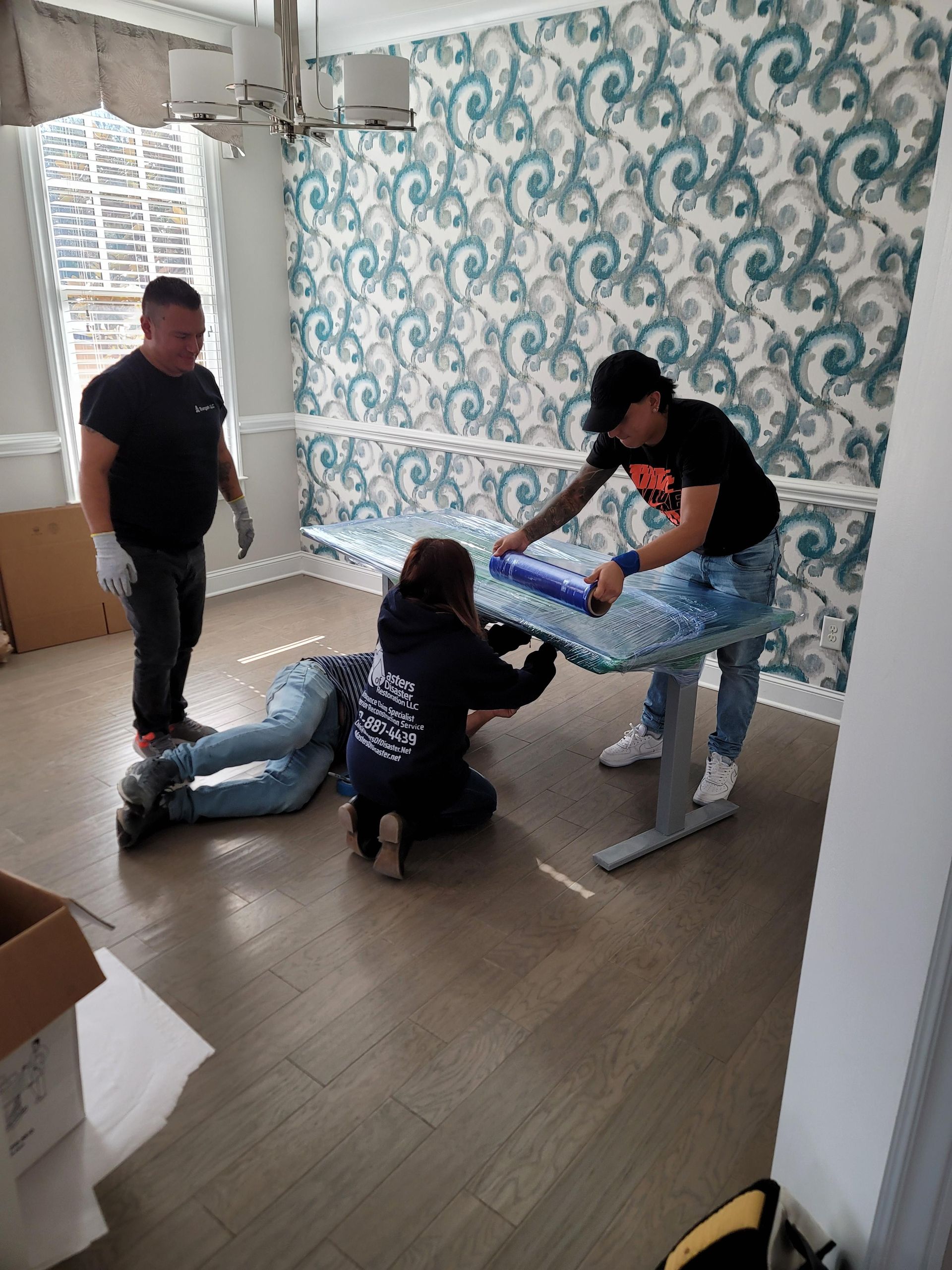 A group of people are working on a table in a room.