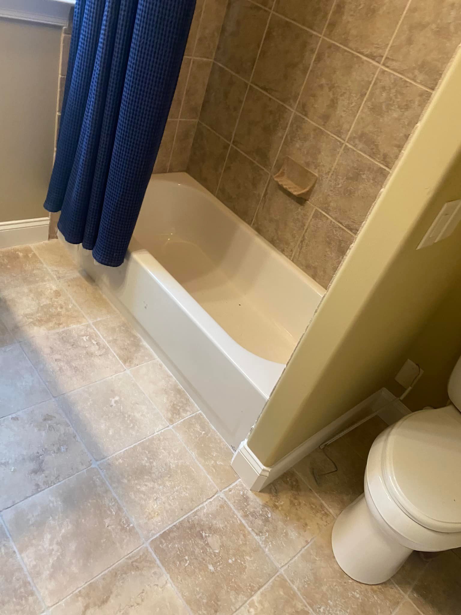 A bathroom with a tub , toilet and shower.