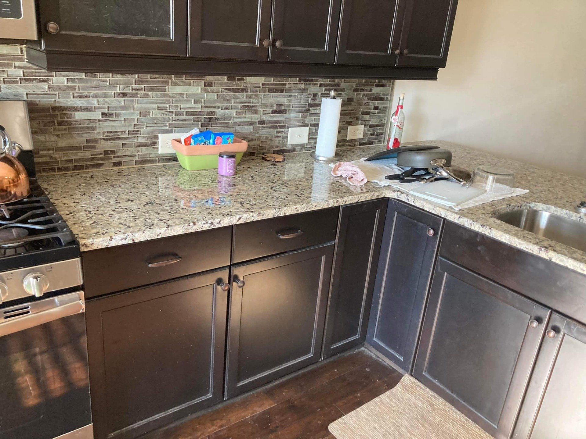 A kitchen with black cabinets and granite counter tops
