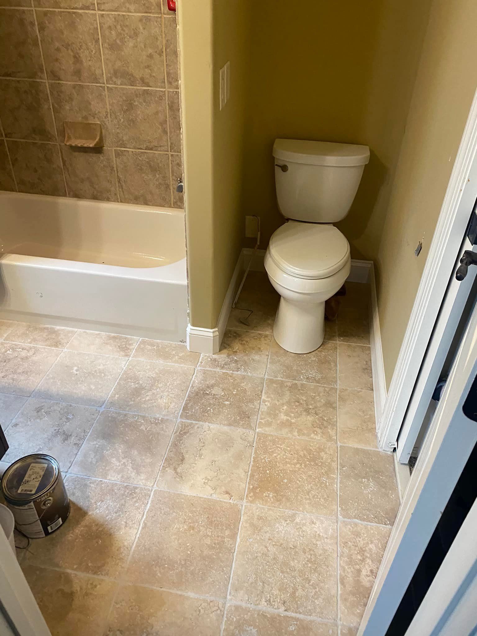 A bathroom with a toilet , tub and shower.