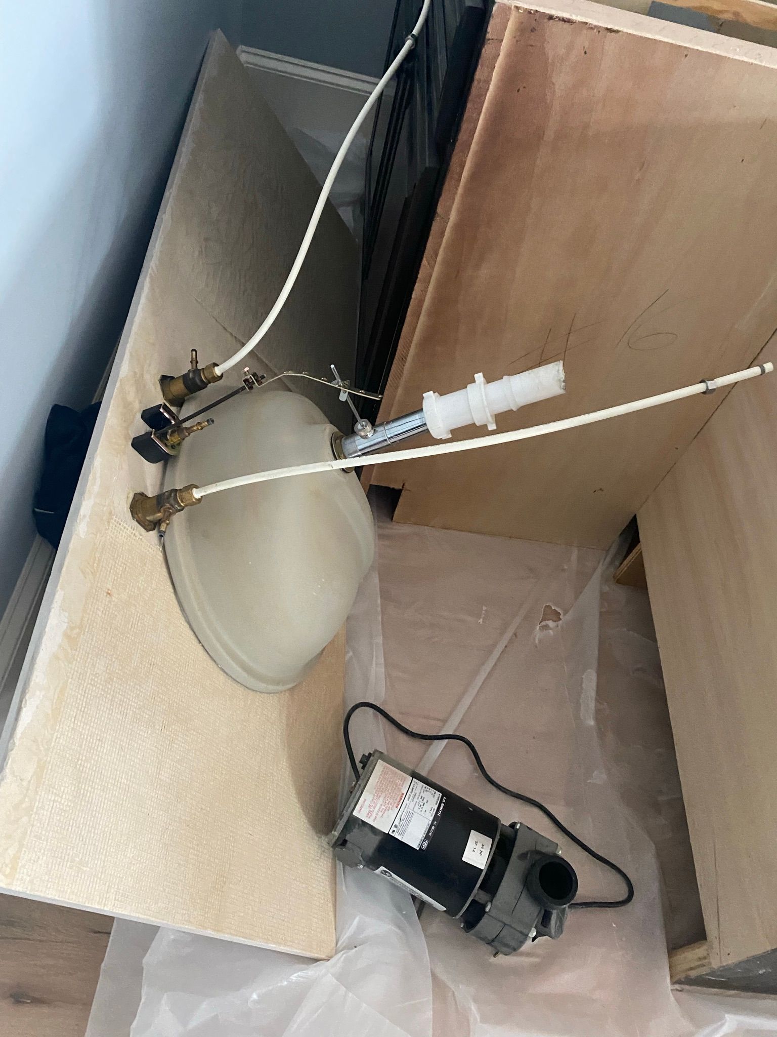 A sink is sitting on top of a wooden counter next to a motor.