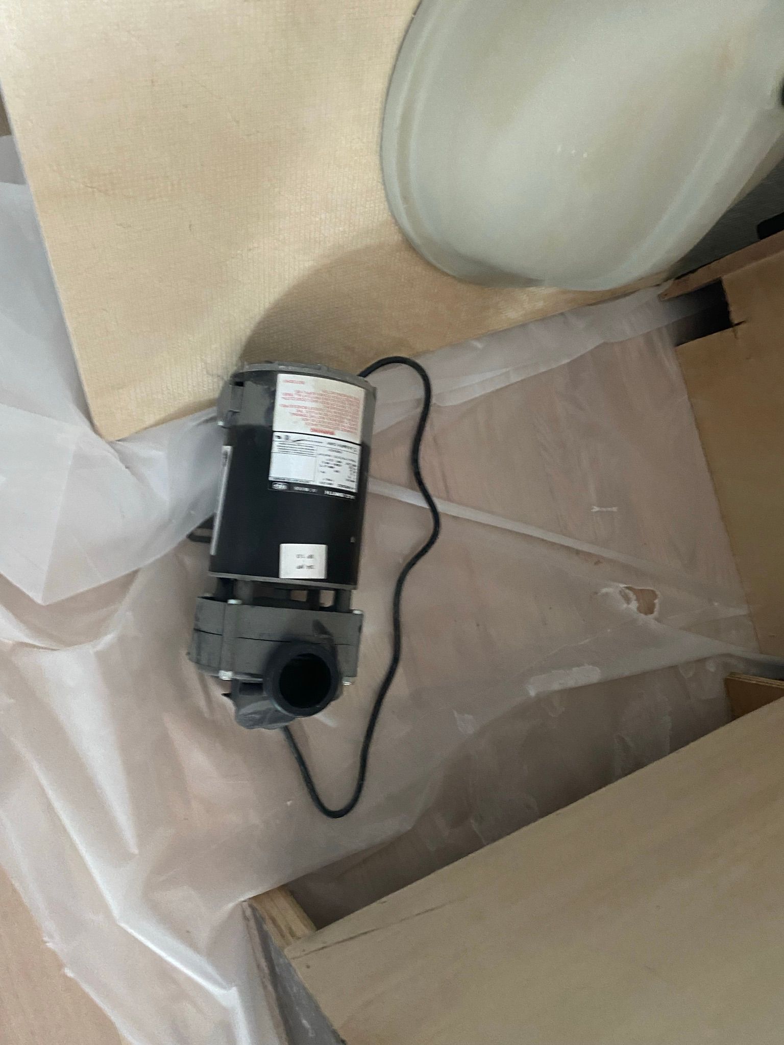 A bathroom fan is sitting on the floor next to a sink.