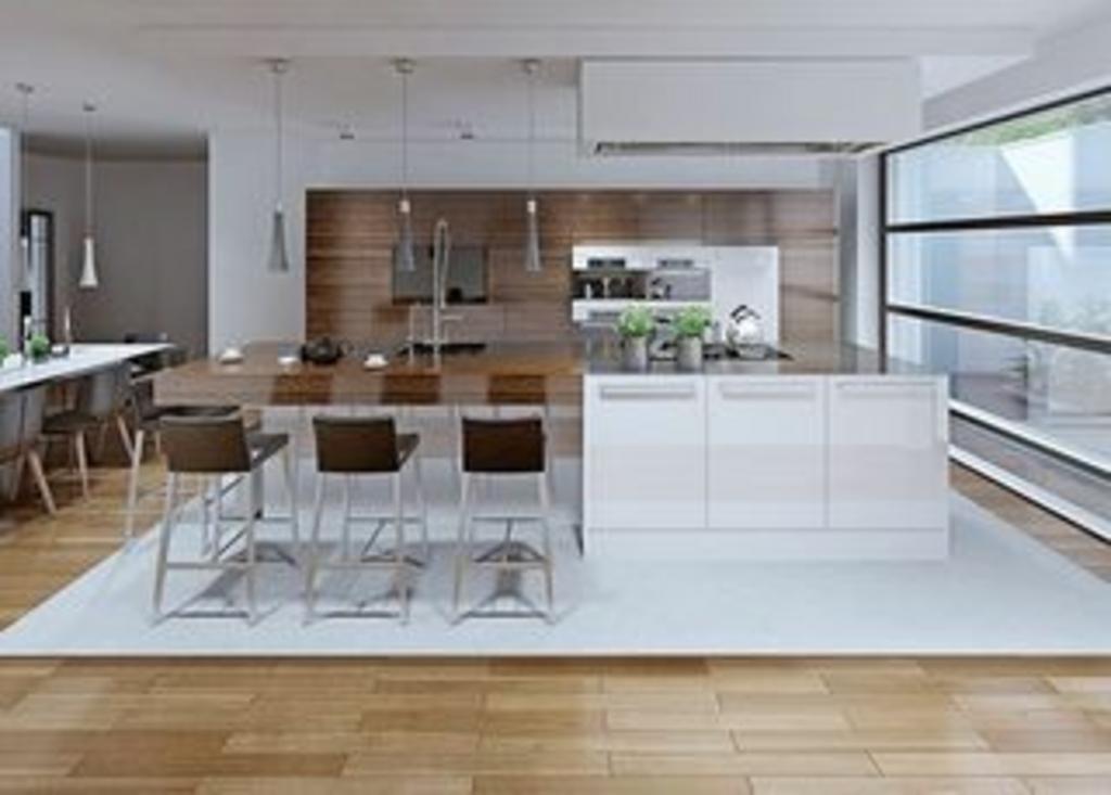 A modern kitchen with white cabinets and wooden floors