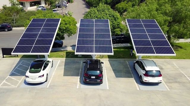 Solar panels on cars in parking lot, capturing solar energy.