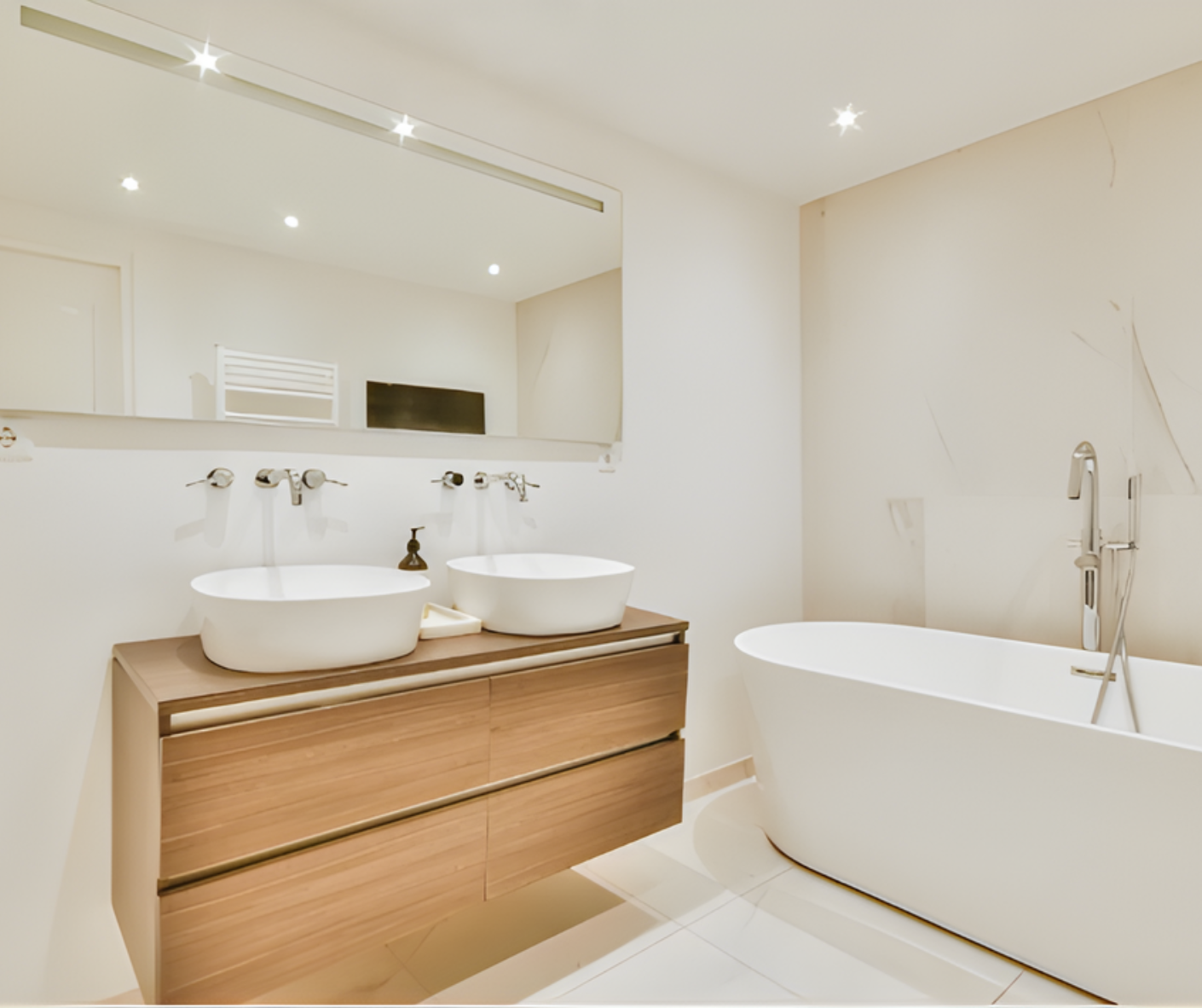 Modern white bathroom with wood vanity, double sinks, mirror, and freestanding tub