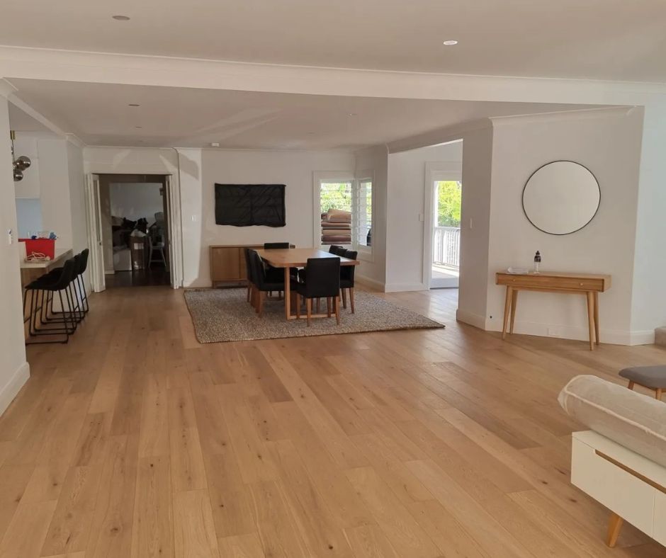 Open-plan living and dining area with timber flooring showcasing modern home improvement.
