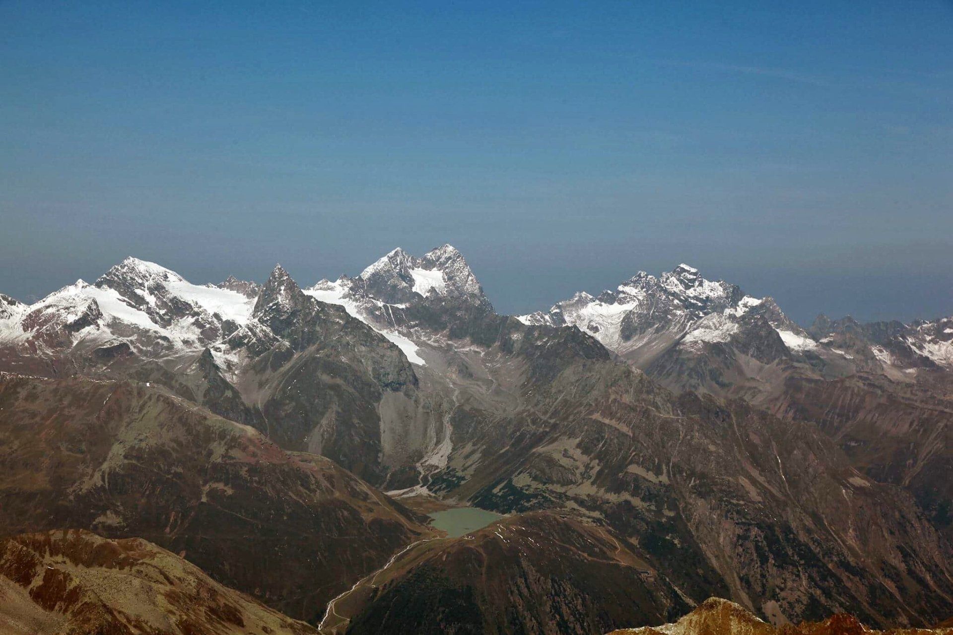 De bergen zijn bedekt met sneeuw en er is een meer in het midden van de bergen.