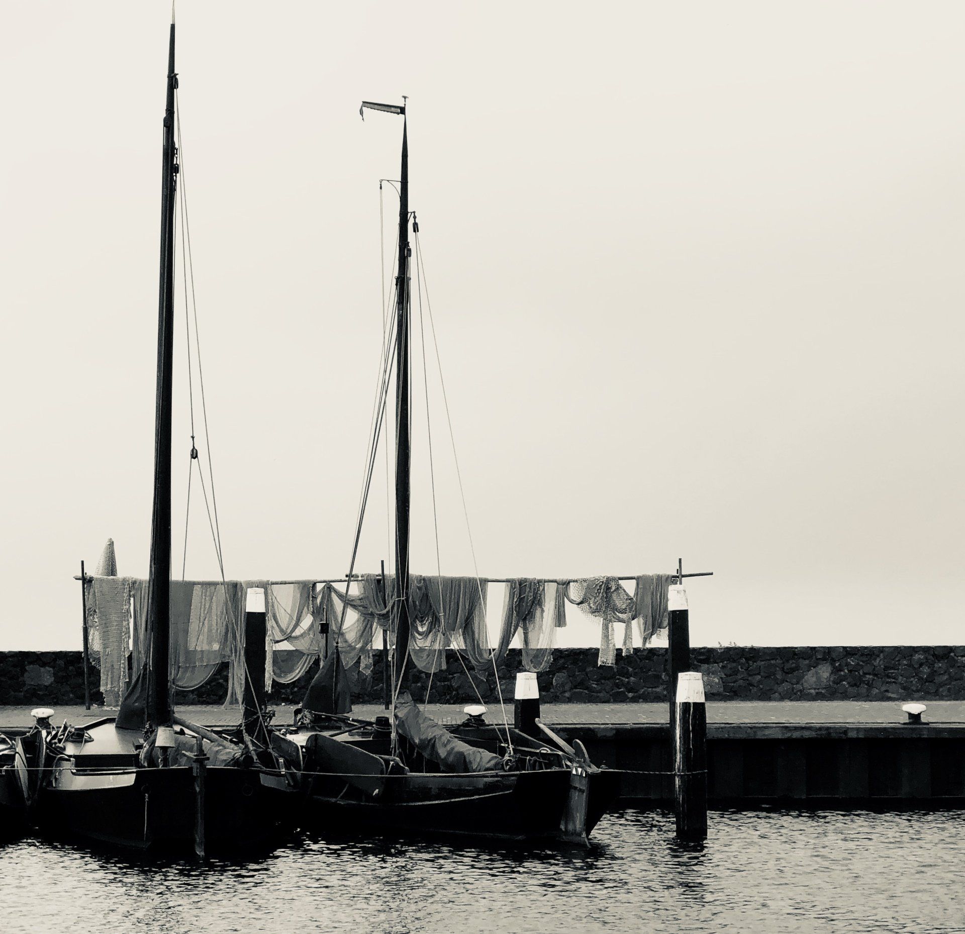 Een zwart-witfoto van boten in de haven van Urk