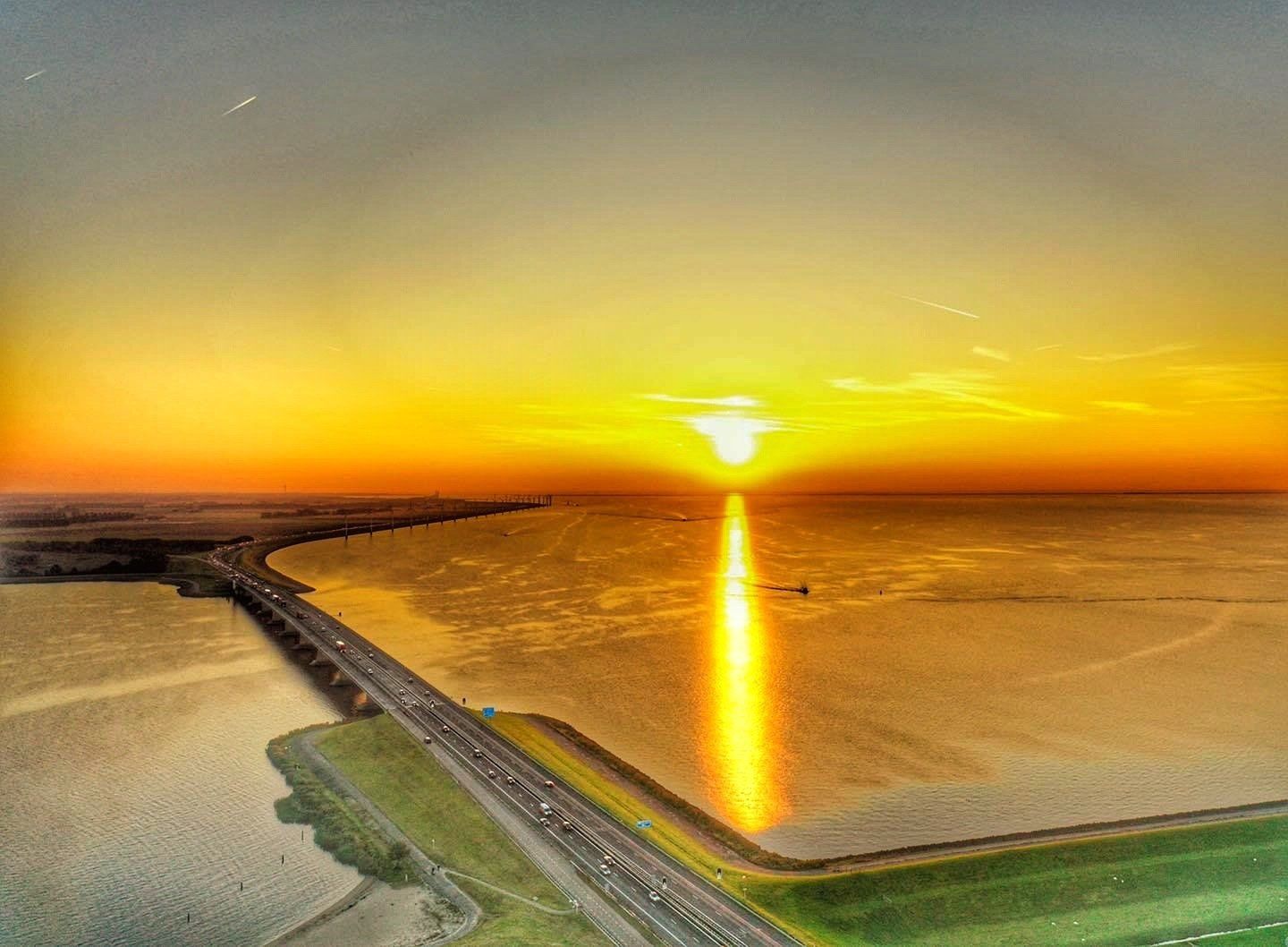 Een luchtfoto van een zonsondergang boven een watermassa.
