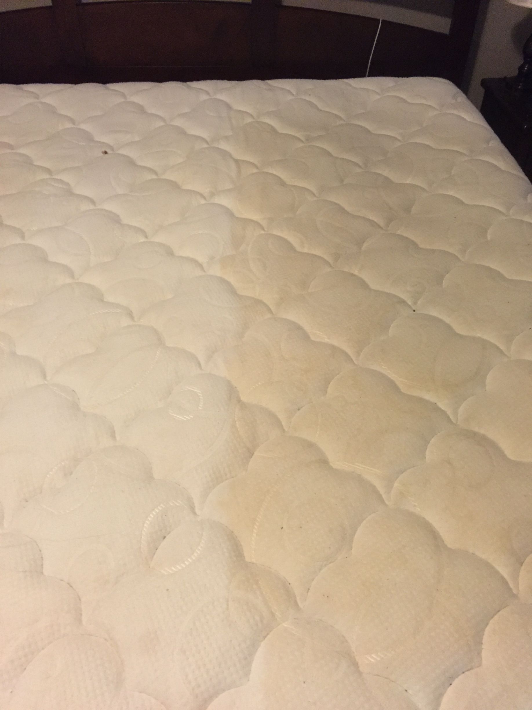 A white mattress is sitting on top of a bed in a bedroom.