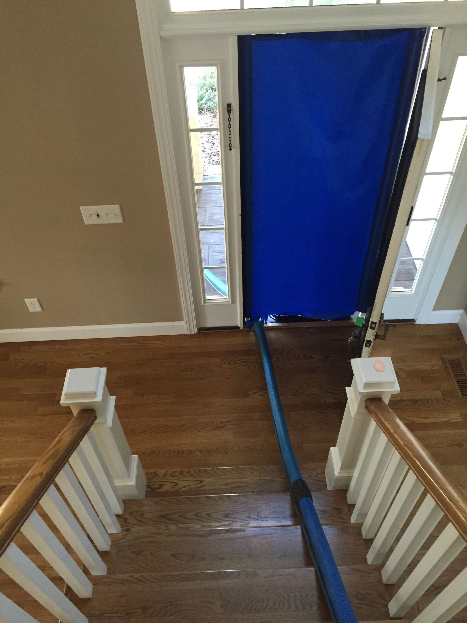 A blue tarp is covering a door in a house