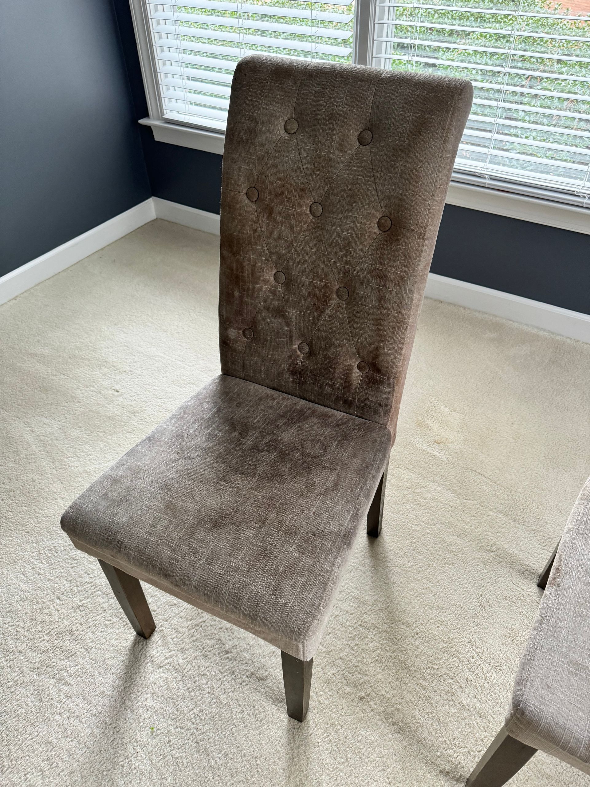 A chair is sitting in a room next to a window.