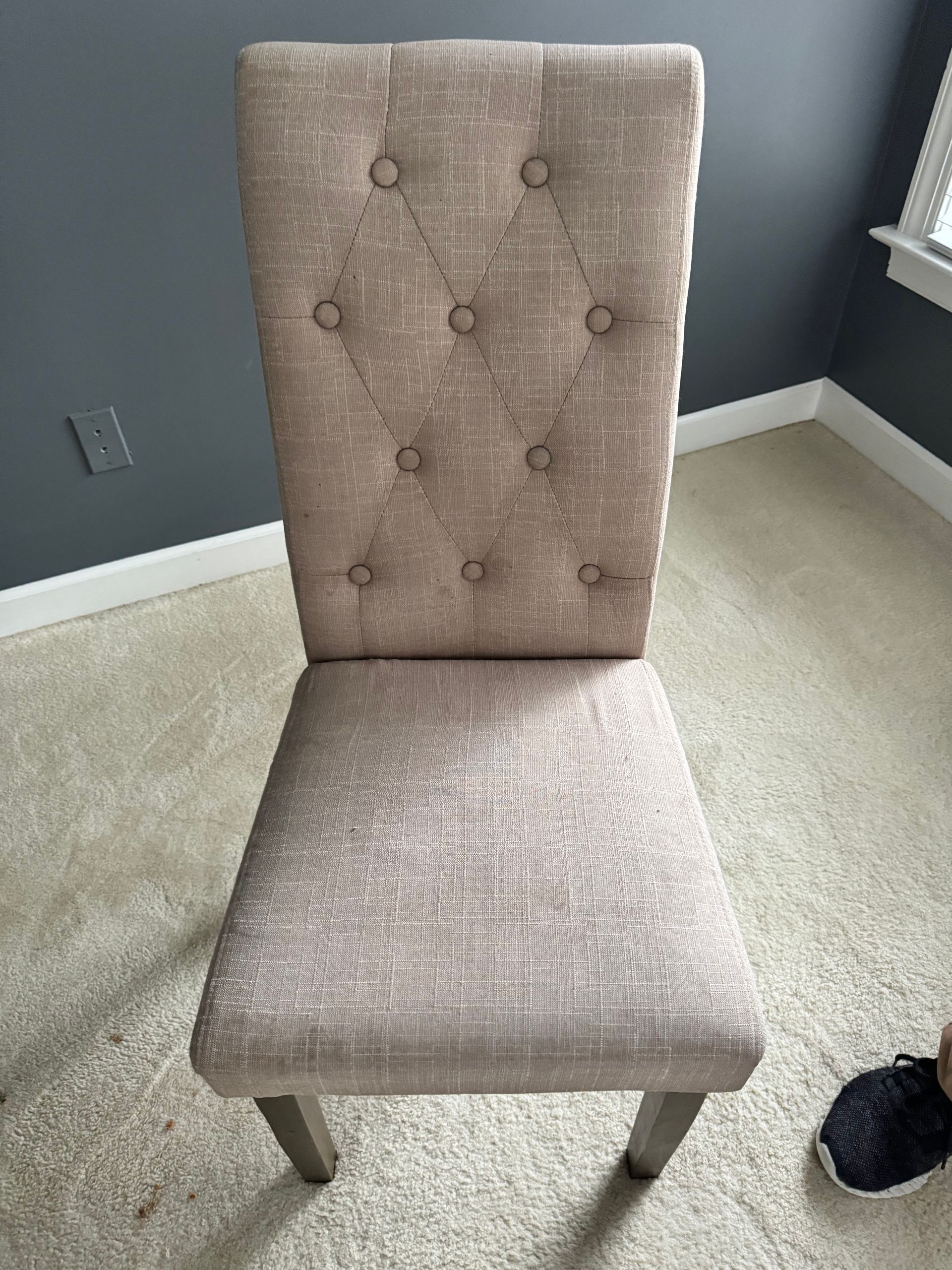 A chair is sitting on a carpet in a room next to a window.
