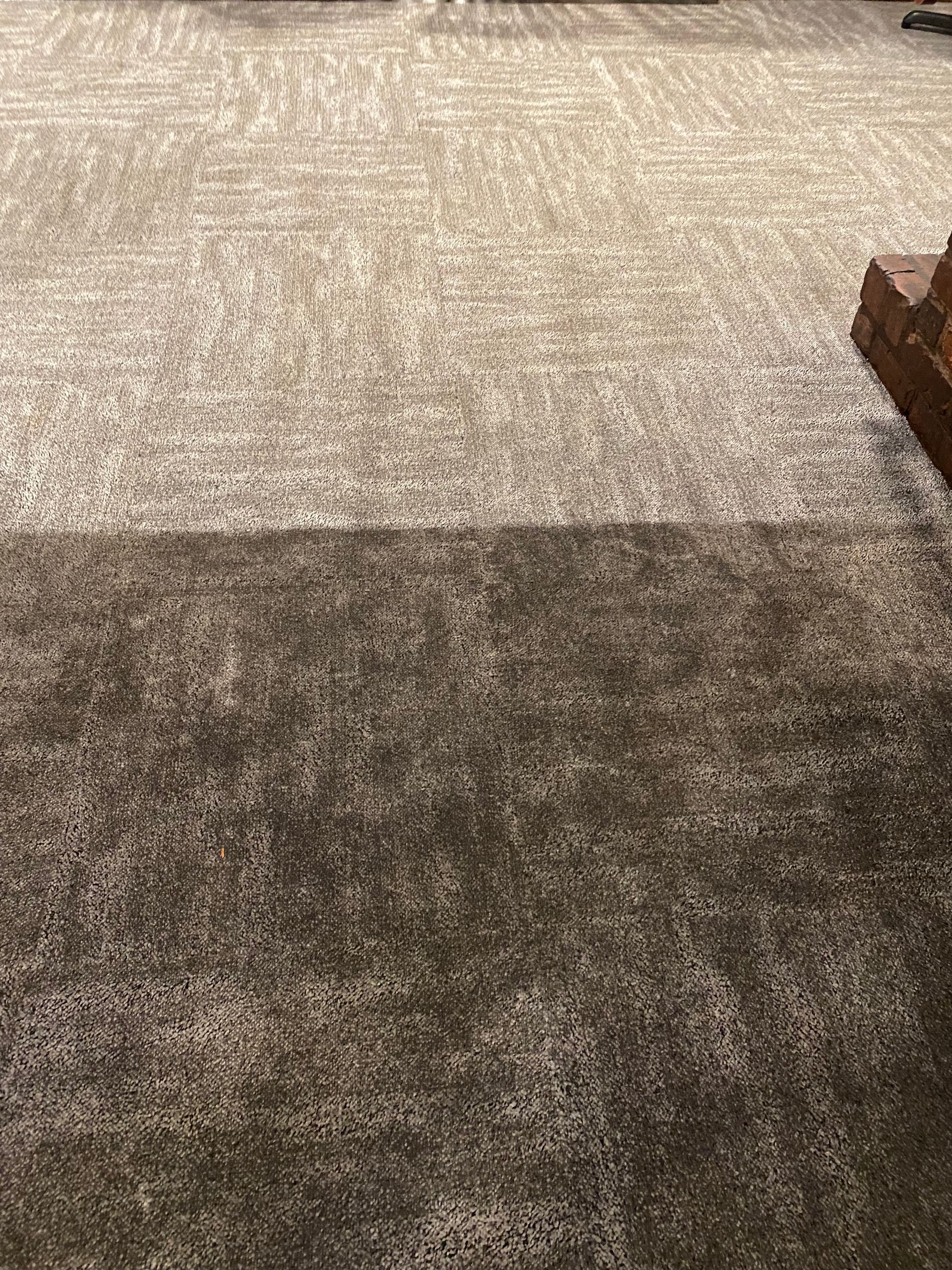 A close up of a carpet with a brick wall in the background.