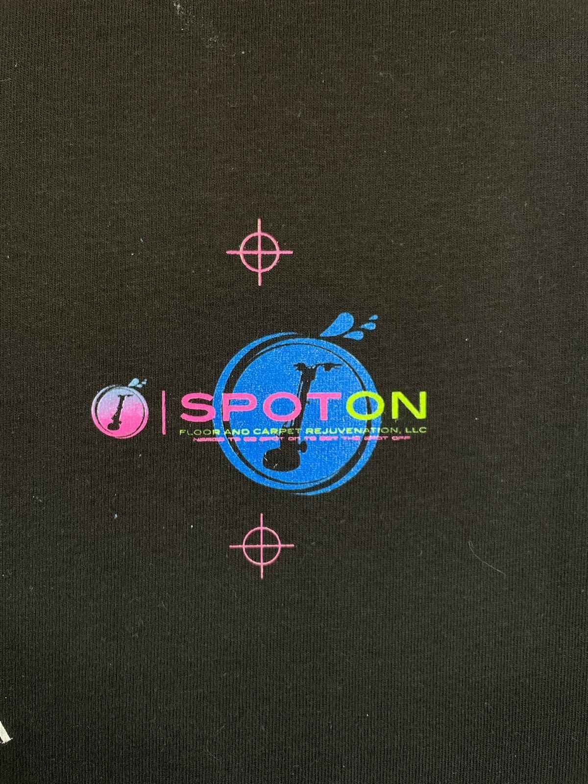 A close up of a black shirt with the word spoton on it.