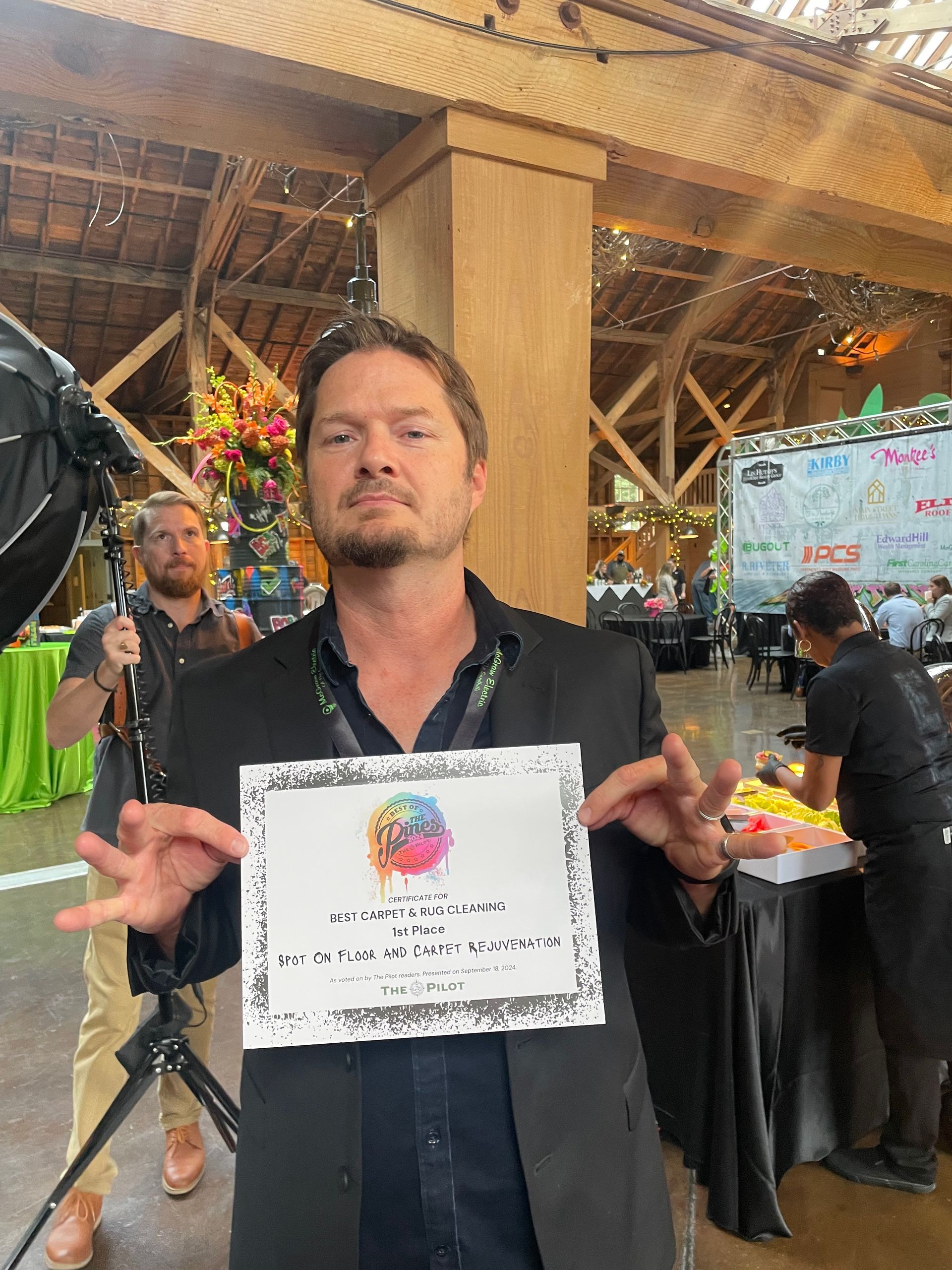 A man in a suit is holding a certificate in his hands.