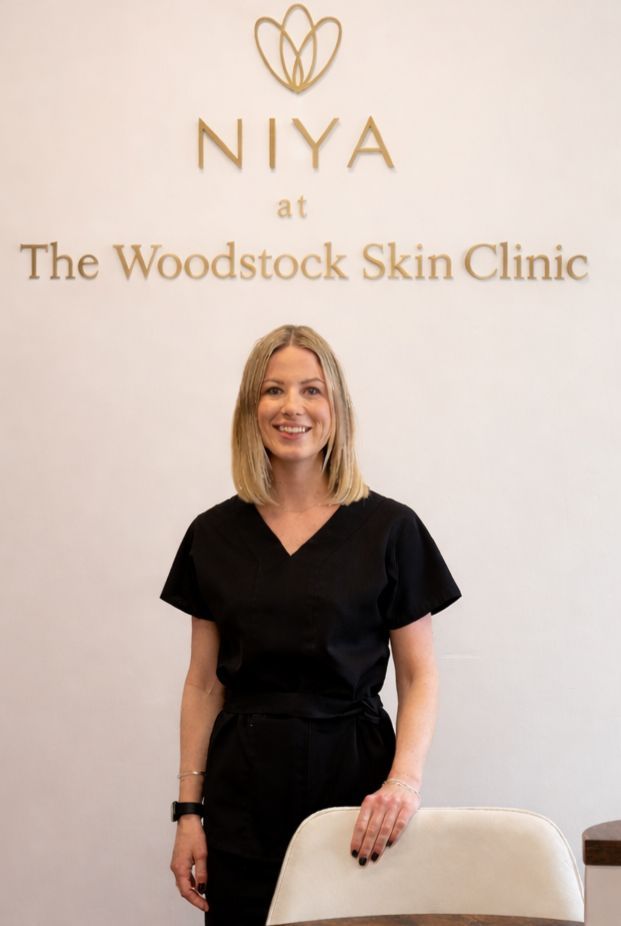 Woman in black scrubs stands in front of