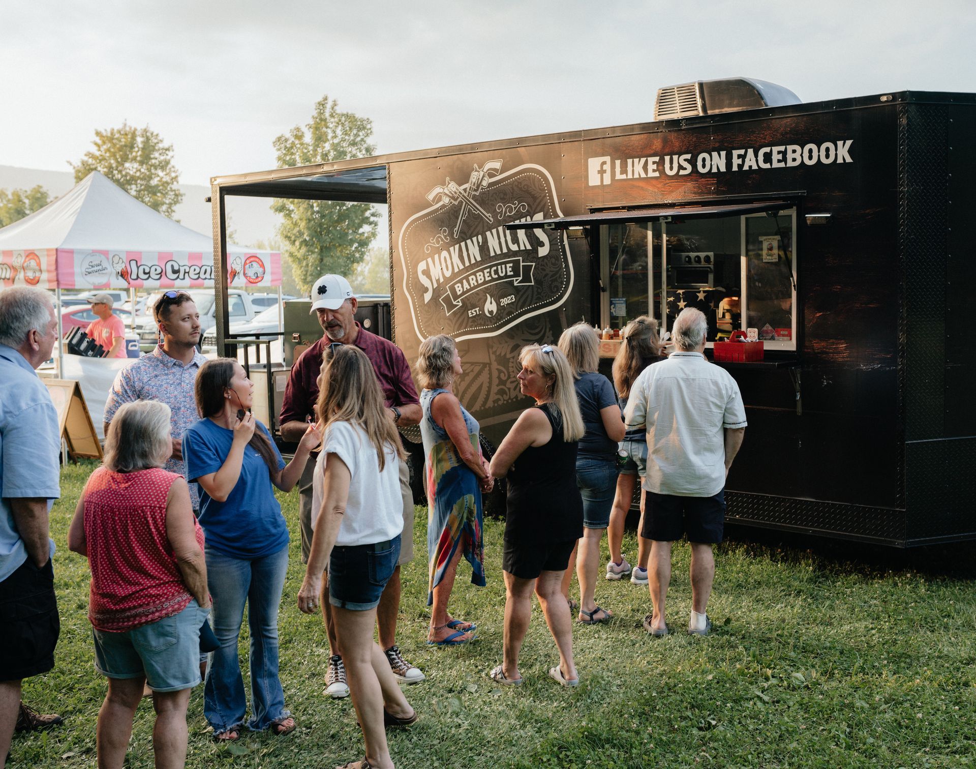 People queue up at a food truck, with a 