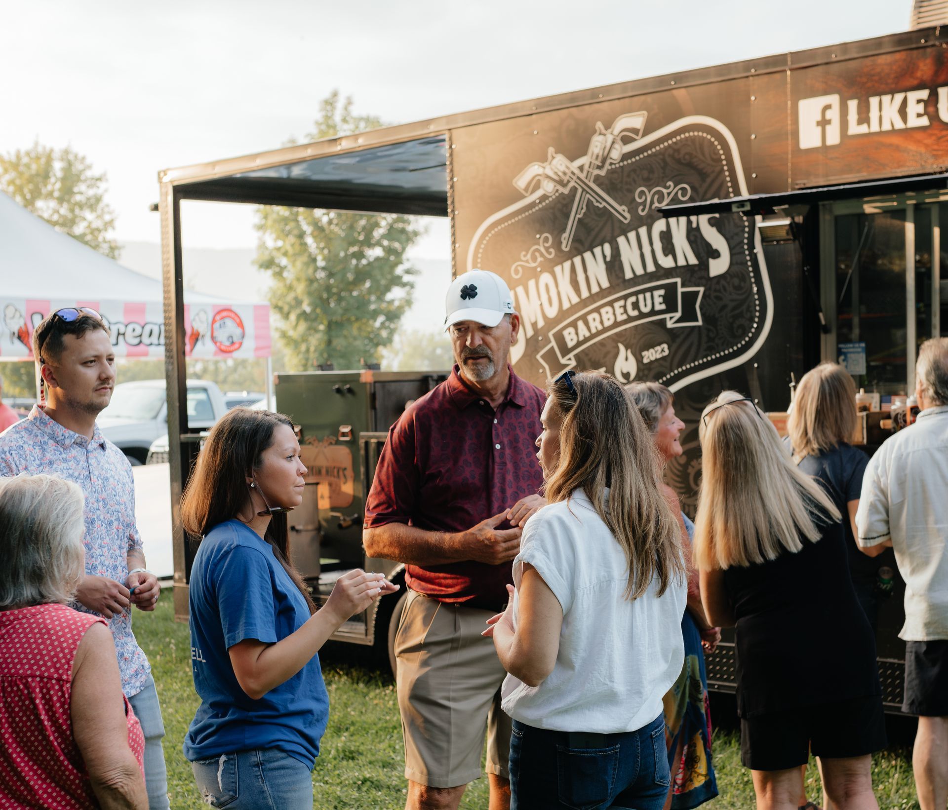 People socializing near a food truck: 