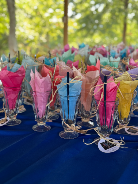 A bunch of glasses filled with tissue paper and straws on a table