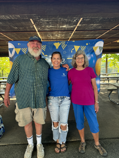 A man and two women are posing for a picture