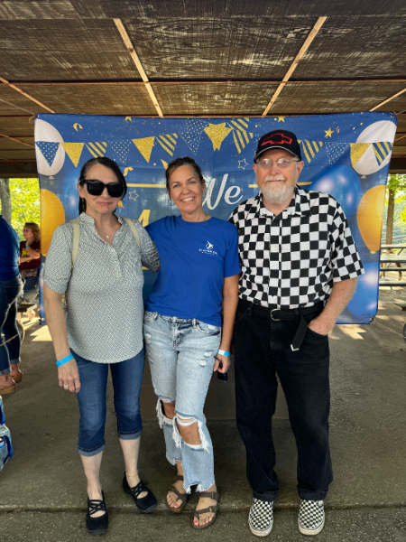 A group of people posing for a picture in front of a sign that says we