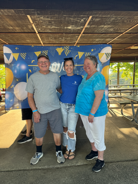 A group of people posing for a picture in front of balloons