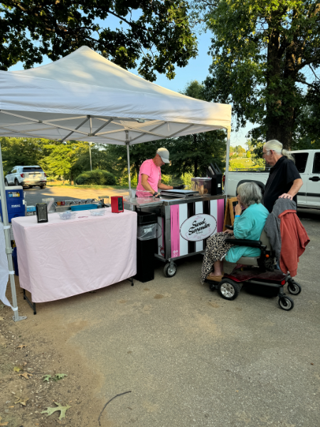 A woman in a wheelchair is standing in front of a tent