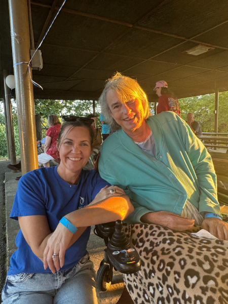 Two women are posing for a picture and one is in a wheelchair