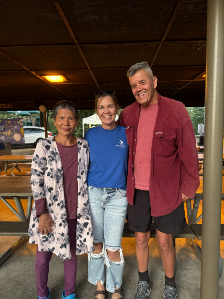 A man and two women are posing for a picture