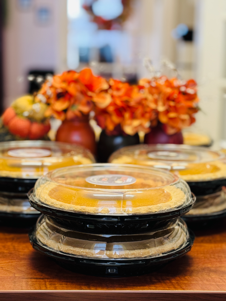 A bunch of pies are stacked on top of each other on a table.