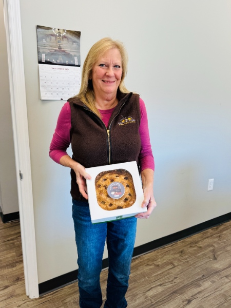 A woman is holding a box with a donut in it