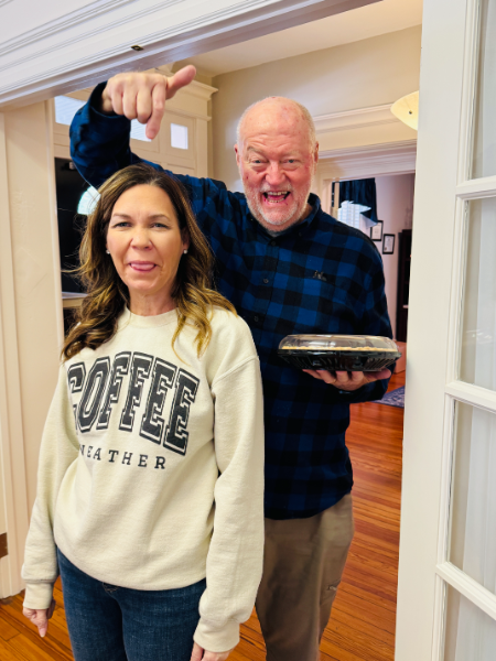 A man is pointing at a woman wearing a coffee sweatshirt