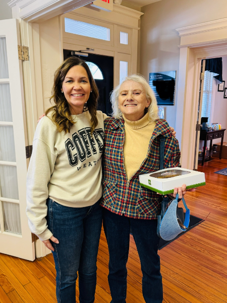 Two women standing next to each other one wearing a sweatshirt that says coffe