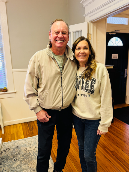 A man and a woman are posing for a picture in a living room.