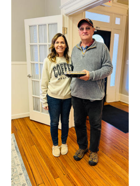 A man and a woman are standing next to each other and the woman is wearing a coffe sweatshirt