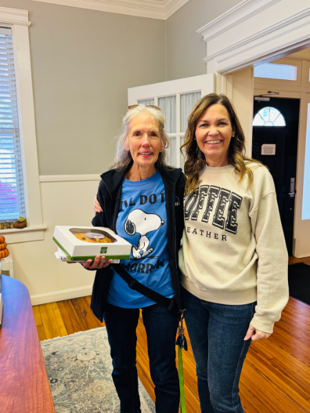 Two women are standing next to each other in a room and one is wearing a snoopy shirt