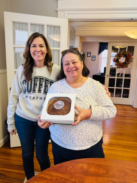 Two women standing next to each other one wearing a sweatshirt that says coffee