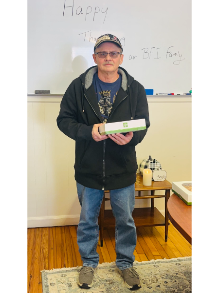 A man standing in front of a white board that says happy