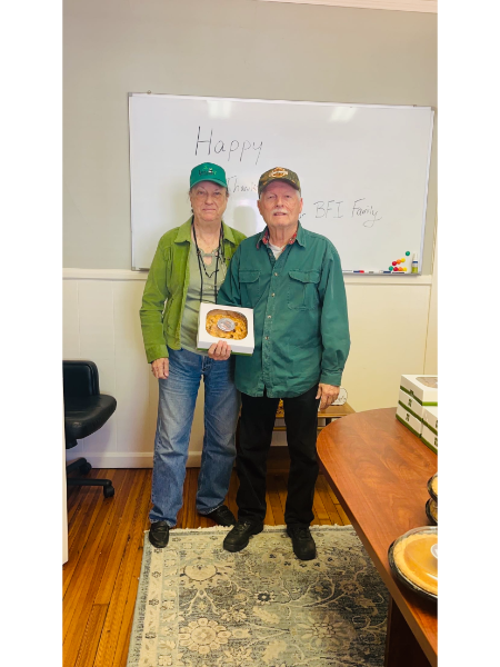 Two people standing in front of a white board that says happy