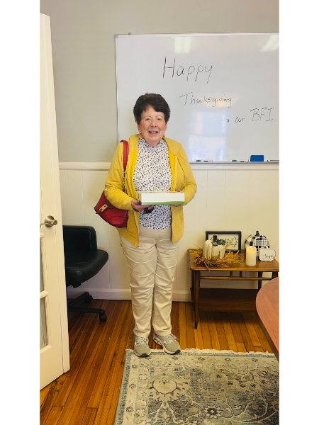 A woman is standing in front of a white board that says happy