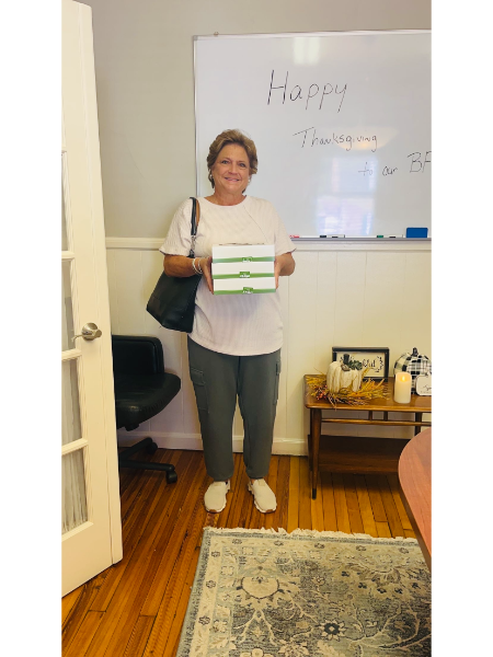 A woman standing in front of a white board that says happy