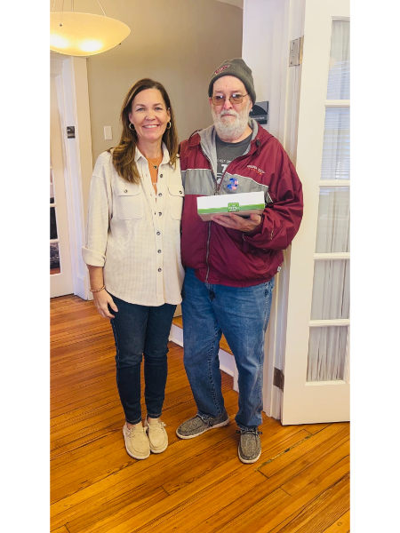 A man and a woman are standing next to each other holding a gift box.