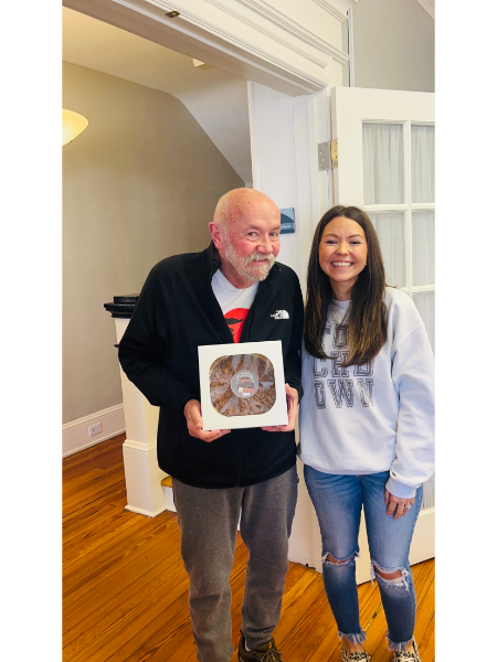 A man and a woman standing next to each other holding a cake