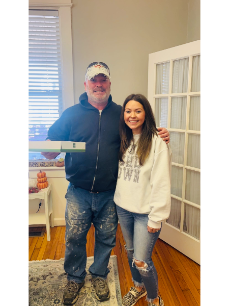 A man and a woman are posing for a picture in a living room.