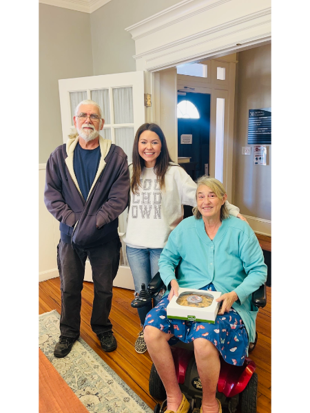 A woman in a wheelchair is posing for a picture with her family