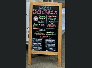 A chalkboard that says local ice cream on it