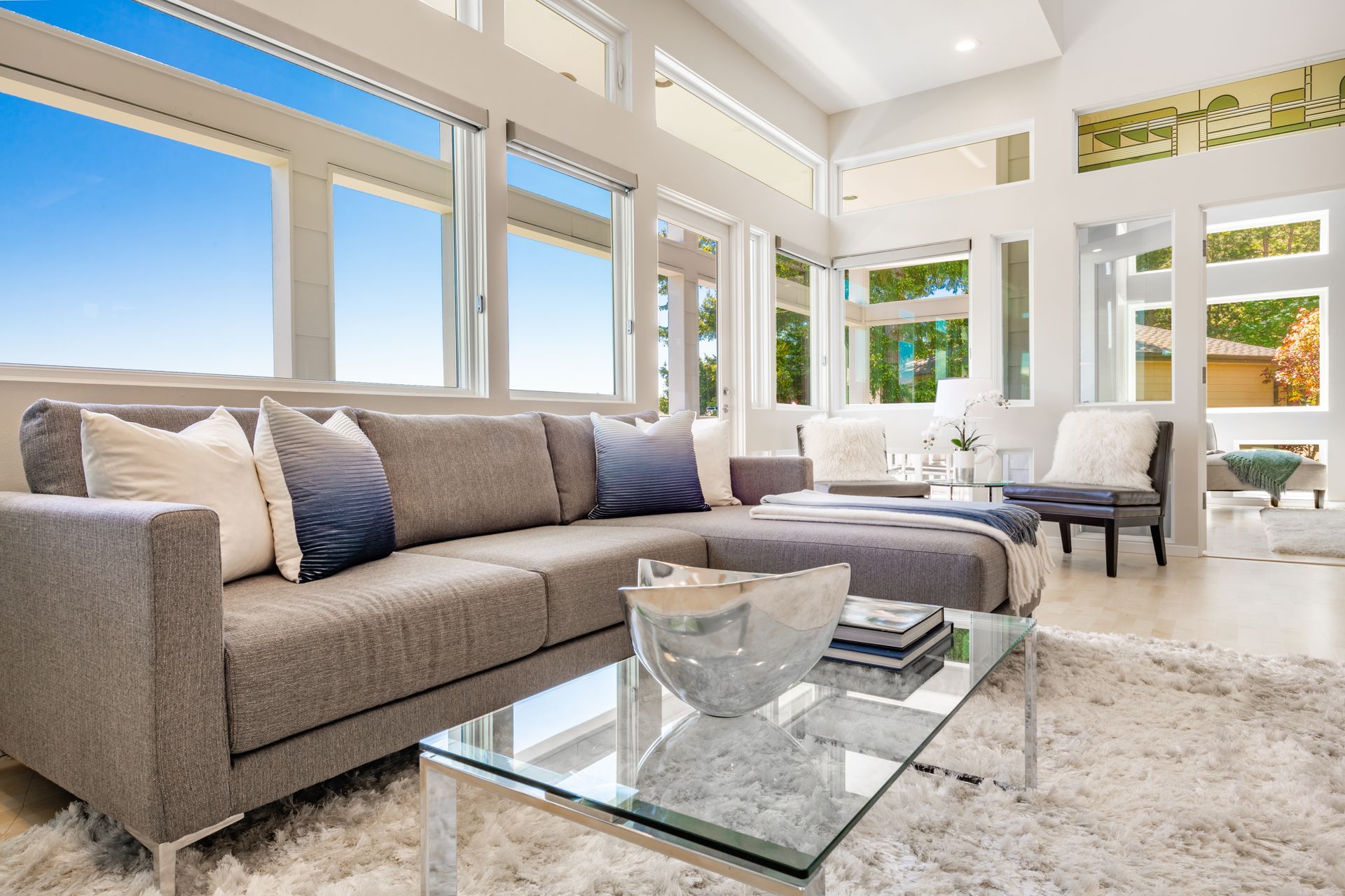 A living room with a couch and a glass coffee table.