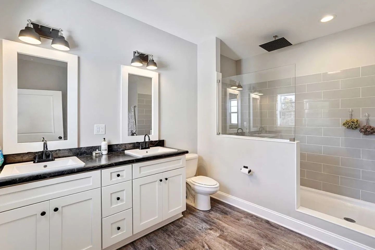 Modern bathroom with white cabinets, marble countertop, black faucets, and a shower with blue textured tile walls.