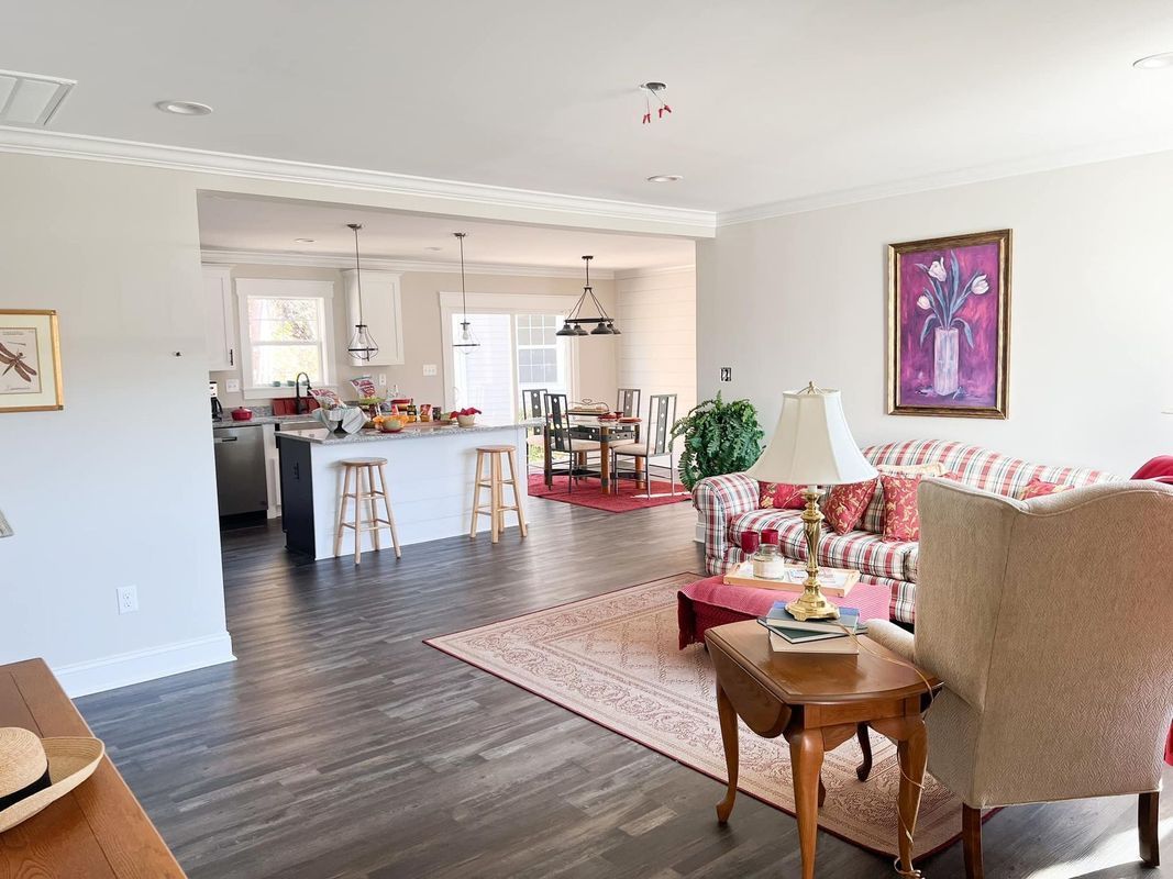 Open floor plan featuring a kitchen with an island, a dining area, and a living space with a sofa and armchair.